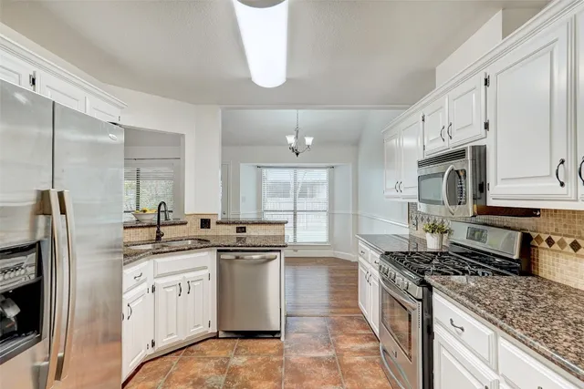 a kitchen with stainless steel appliances a sink stove and refrigerator