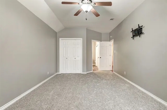 a view of an empty room with a ceiling fan