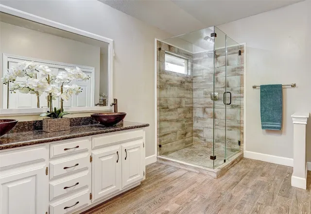 a bathroom with double vanity and a shower