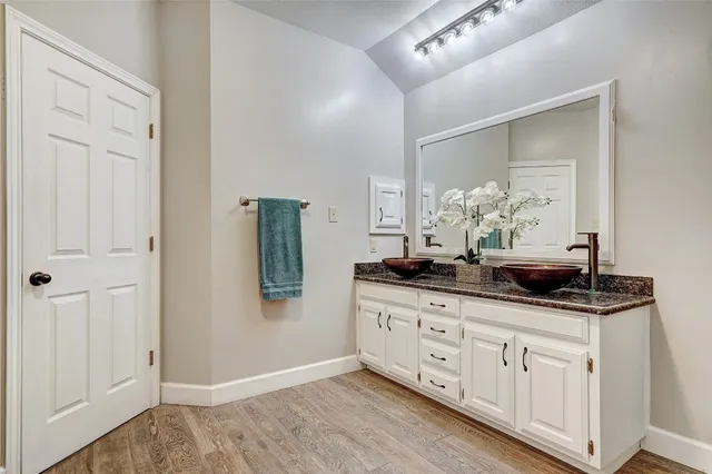 a room with white cabinets and sink