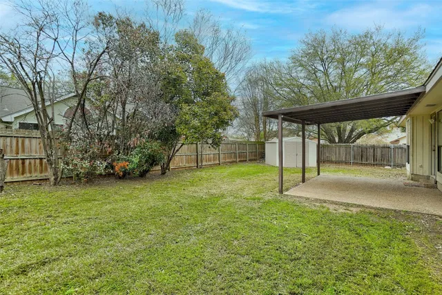 a view of a house with backyard and a tree