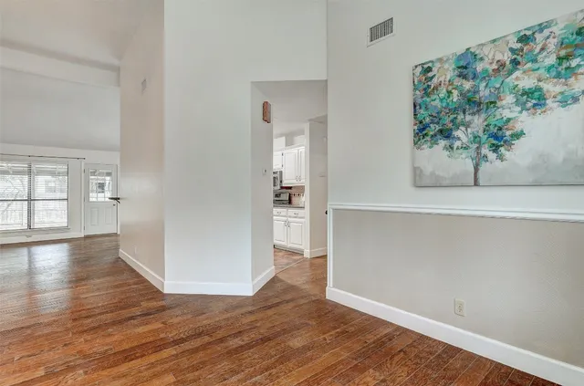 an empty room with wooden floor and a painting on the wall