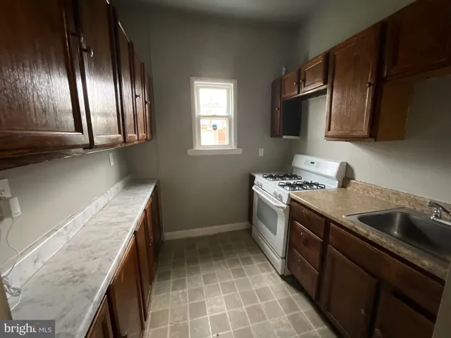 a kitchen with a sink a stove and cabinets