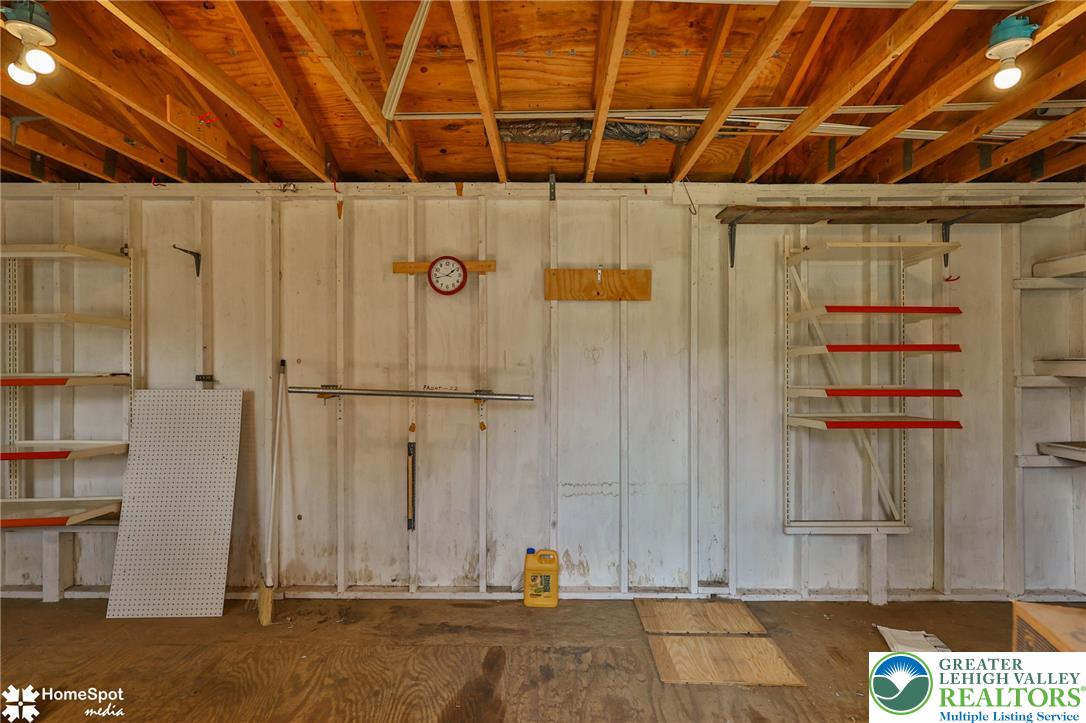 3069 Shakespeare Road Bethlehem, PA 18017 - Photo 49 of 50 A well-lit garage with exposed wooden beams, providing ample storage with built-in shelving.