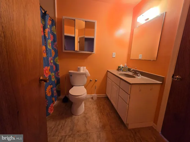 a bathroom with a toilet a sink and mirror