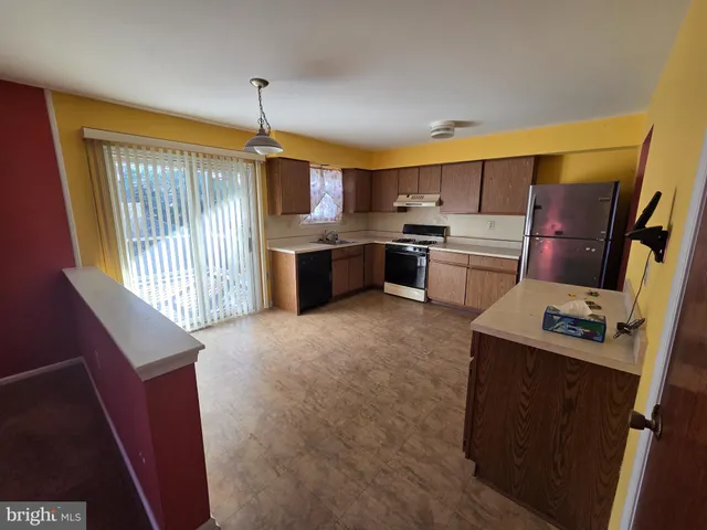 a kitchen with kitchen island granite countertop a sink stove and refrigerator