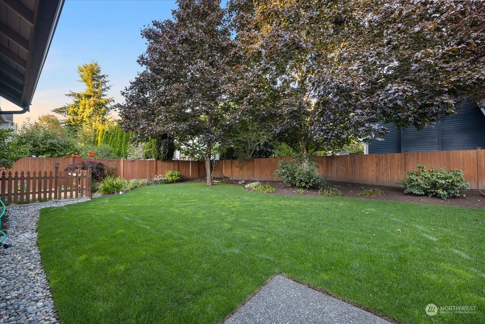 15114 92nd Place Northeast Bothell, WA 98011 - Photo 29 of 34 a view of a backyard with plants and a bench