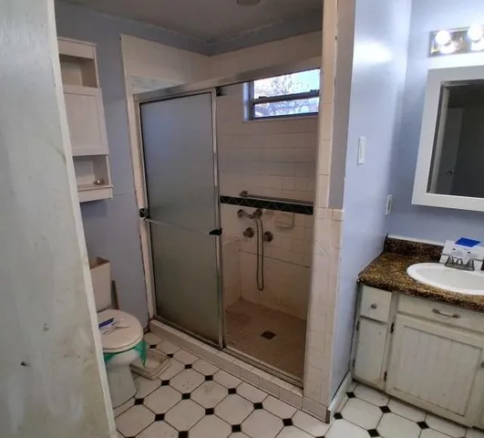 a bathroom with a granite countertop sink toilet and shower