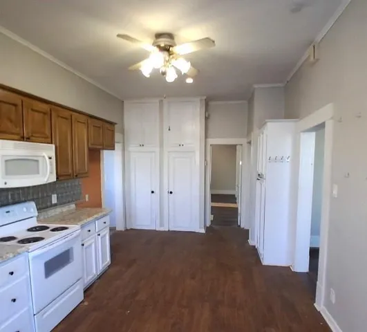 a kitchen with kitchen island granite countertop a sink cabinets and stainless steel appliances