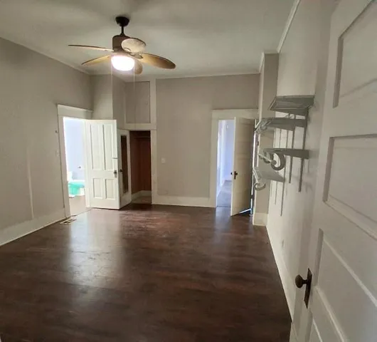 an empty room with wooden floor and staircase