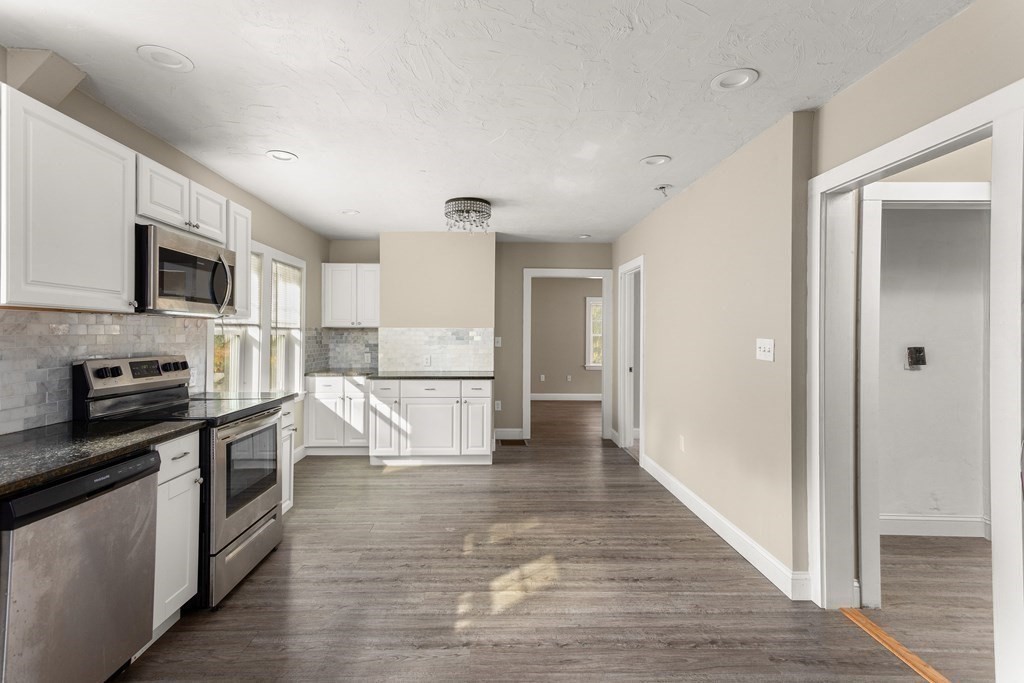 195 Eastern Avenue Worcester, MA 01605 - Photo 6 of 24 a kitchen with stainless steel appliances granite countertop a refrigerator and a stove top oven