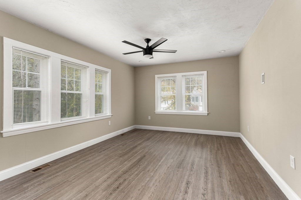 195 Eastern Avenue Worcester, MA 01605 - Photo 8 of 24 an empty room with wooden floor ceiling fan and windows