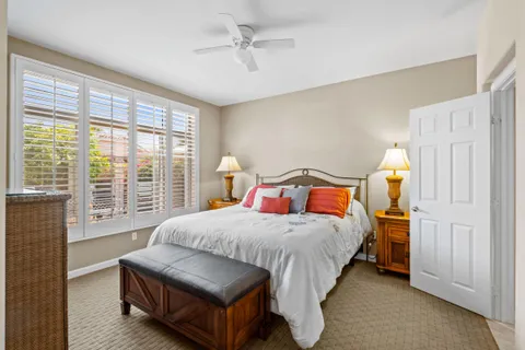 a bedroom with a large bed and large windows