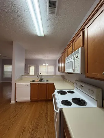 a kitchen with a sink a stove top oven and cabinetry