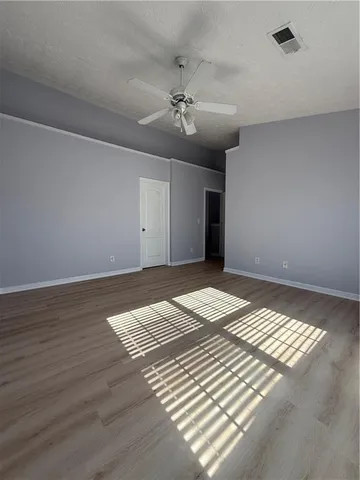 a view of a livingroom with wooden floor and a ceiling fan