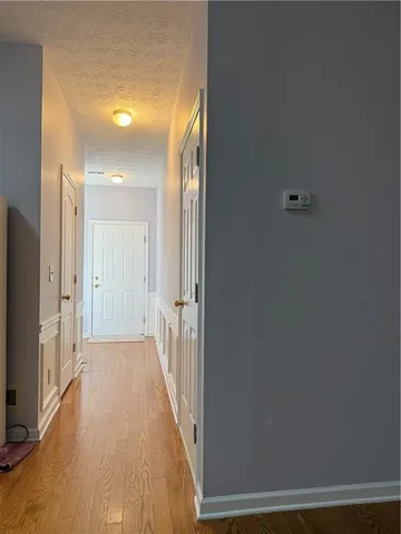a view of a hallway with wooden floor and a cabinet