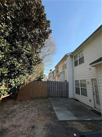 a view of a house with a backyard and a tree