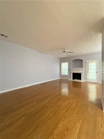a view of empty room with wooden floor and fireplace