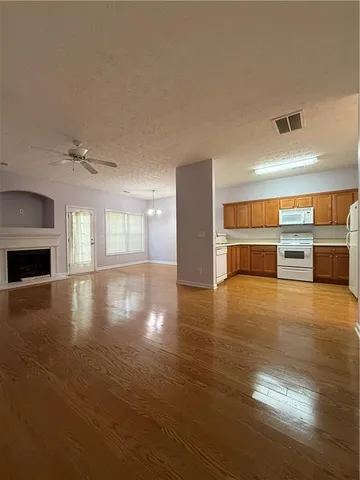 a view of empty room with wooden floor and fireplace