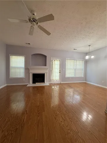 a view of empty room with wooden floor and fireplace