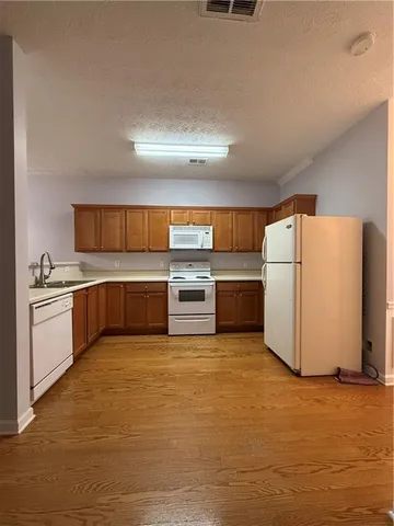 a kitchen with wooden cabinets and white stainless steel appliances