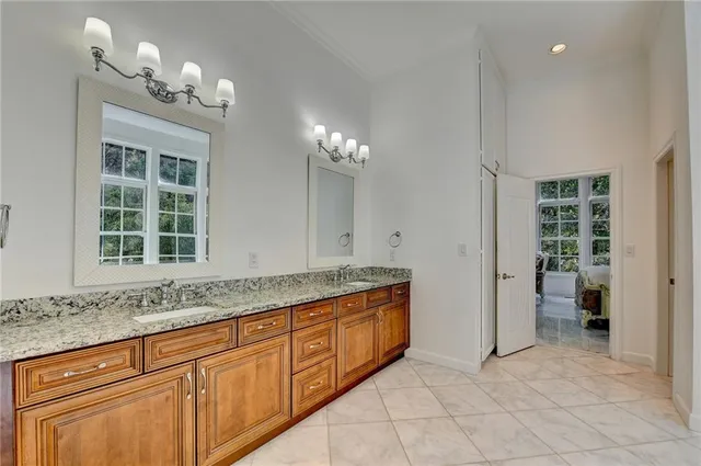 a bathroom with a granite countertop sink a toilet a mirror a vanity and shower