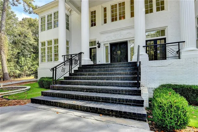 a view of staircase with lots of frames on wall and a window
