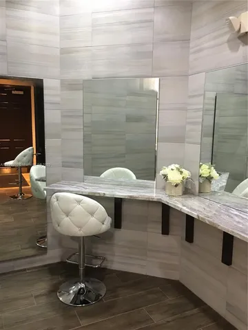 a view of a bathroom with a granite countertop sink a mirror and a potted plant