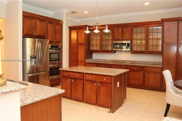 a kitchen with stainless steel appliances granite countertop a refrigerator and a stove top oven