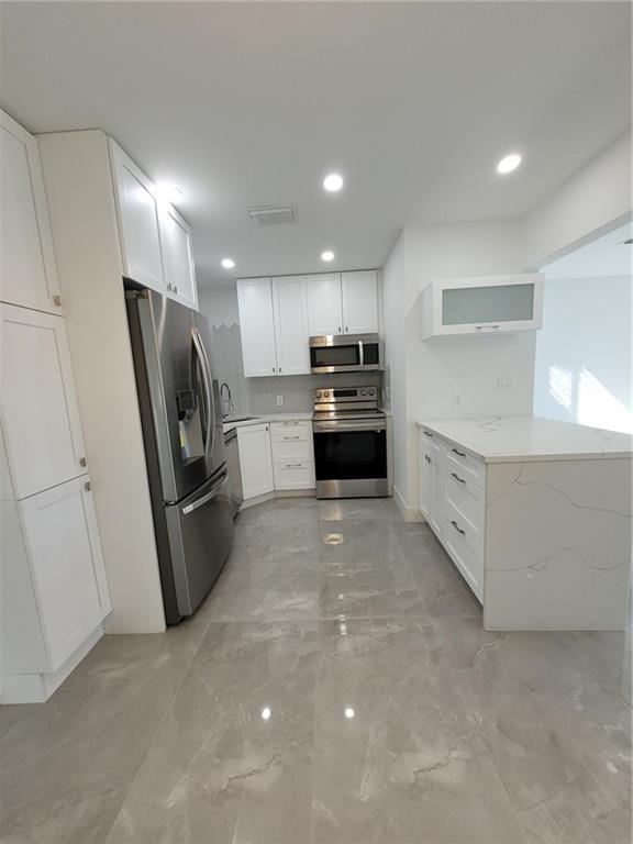 6041 Southwest 17th Street Miami, FL 33155 - Photo 4 of 26 a kitchen with stainless steel appliances a refrigerator stove microwave and sink