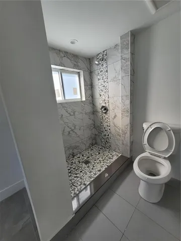 a bathroom with a toilet and a shower