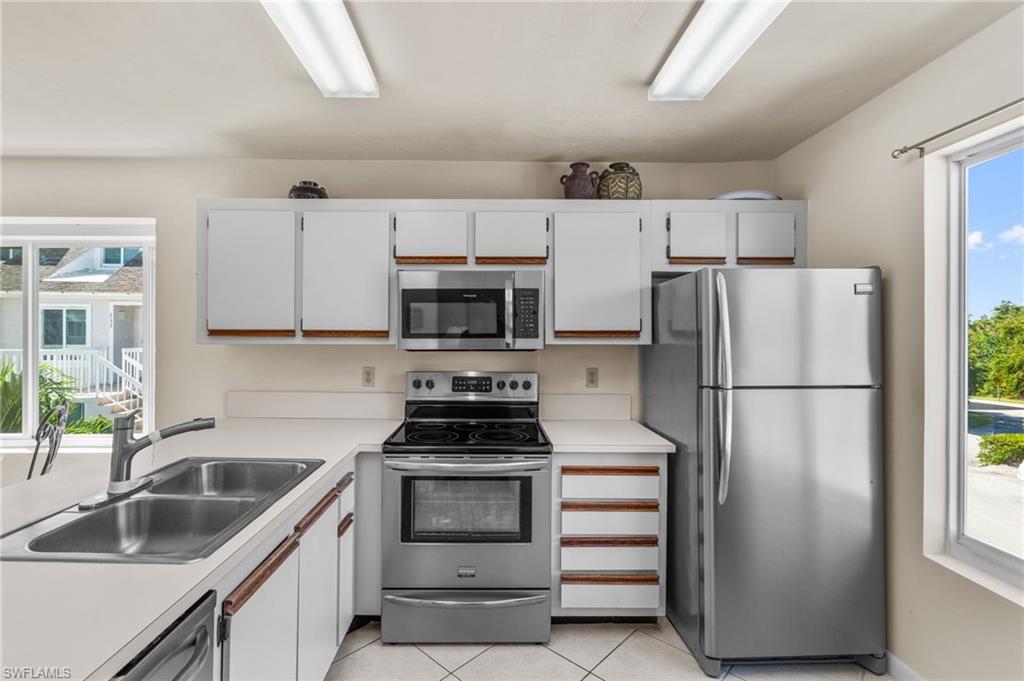 2155 San Marco Road, Unit 2204 Marco Island, FL 34145 - Photo 5 of 22 a kitchen with refrigerator a sink and white cabinets