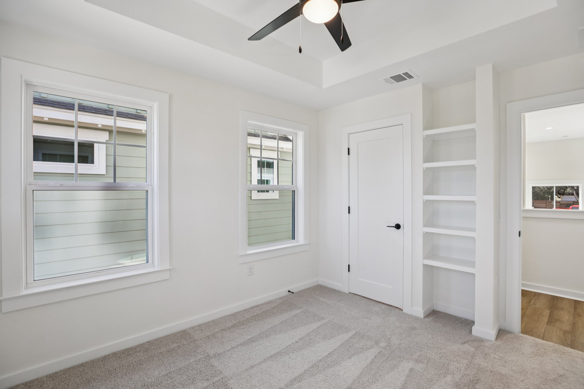 2414 Drew Lane, Unit 5 Austin, TX 78748 - Photo 14 of 24 Unfurnished bedroom featuring light colored carpet, a tray ceiling, and a ceiling fan