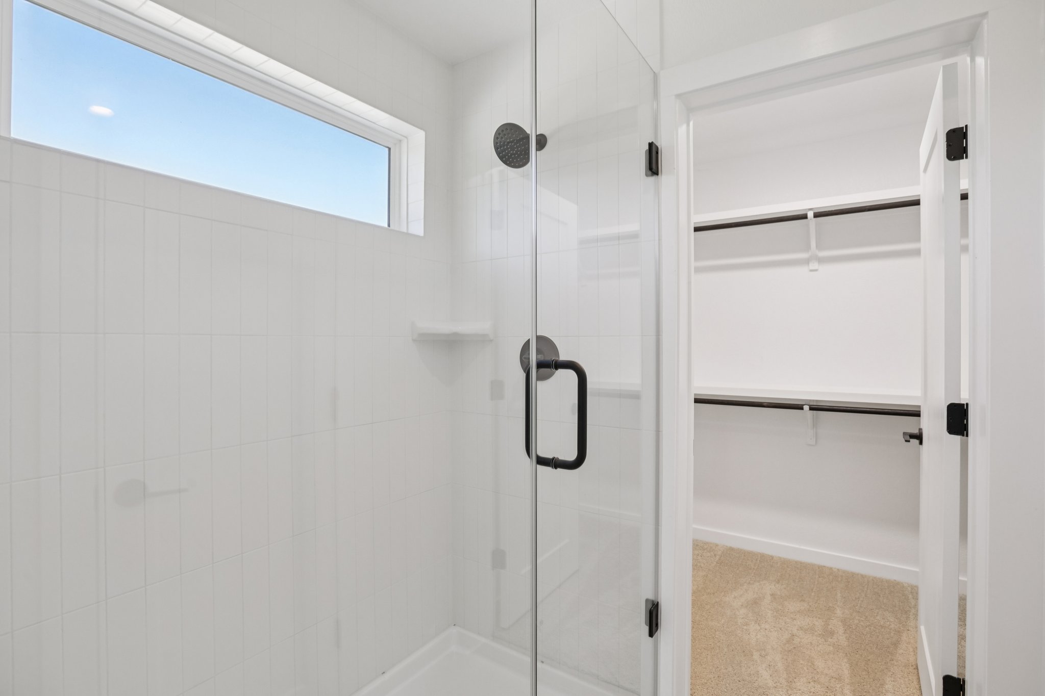 2414 Drew Lane, Unit 5 Austin, TX 78748 - Photo 20 of 24 Bathroom featuring a stall shower, a walk in closet, and light colored carpet