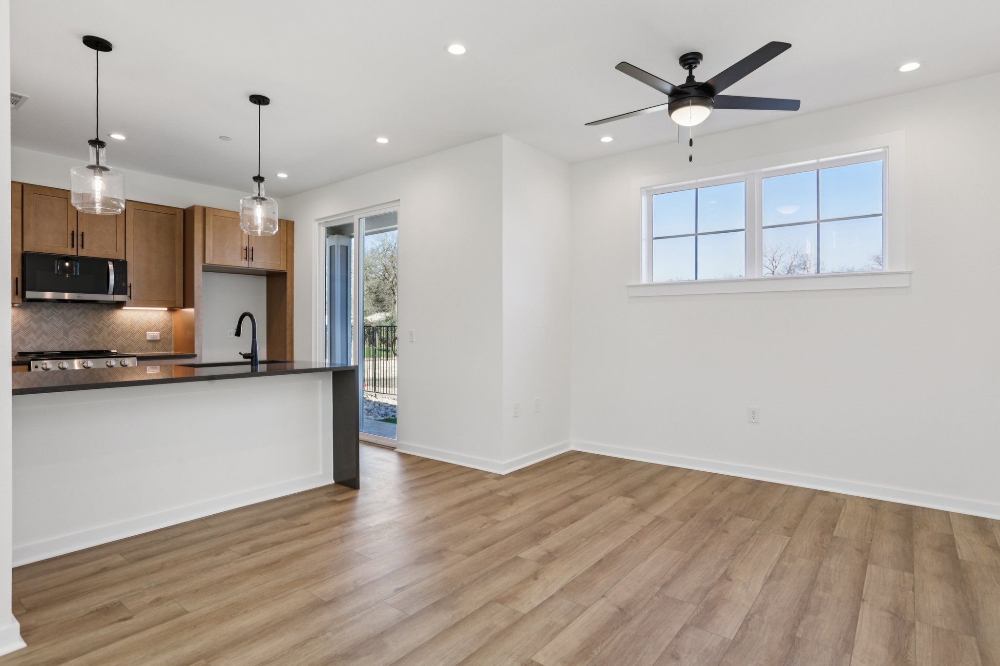 2414 Drew Lane, Unit 5 Austin, TX 78748 - Photo 7 of 24 Kitchen featuring decorative light fixtures, stainless steel microwave, light wood-style floors, recessed lighting, and a ceiling fan