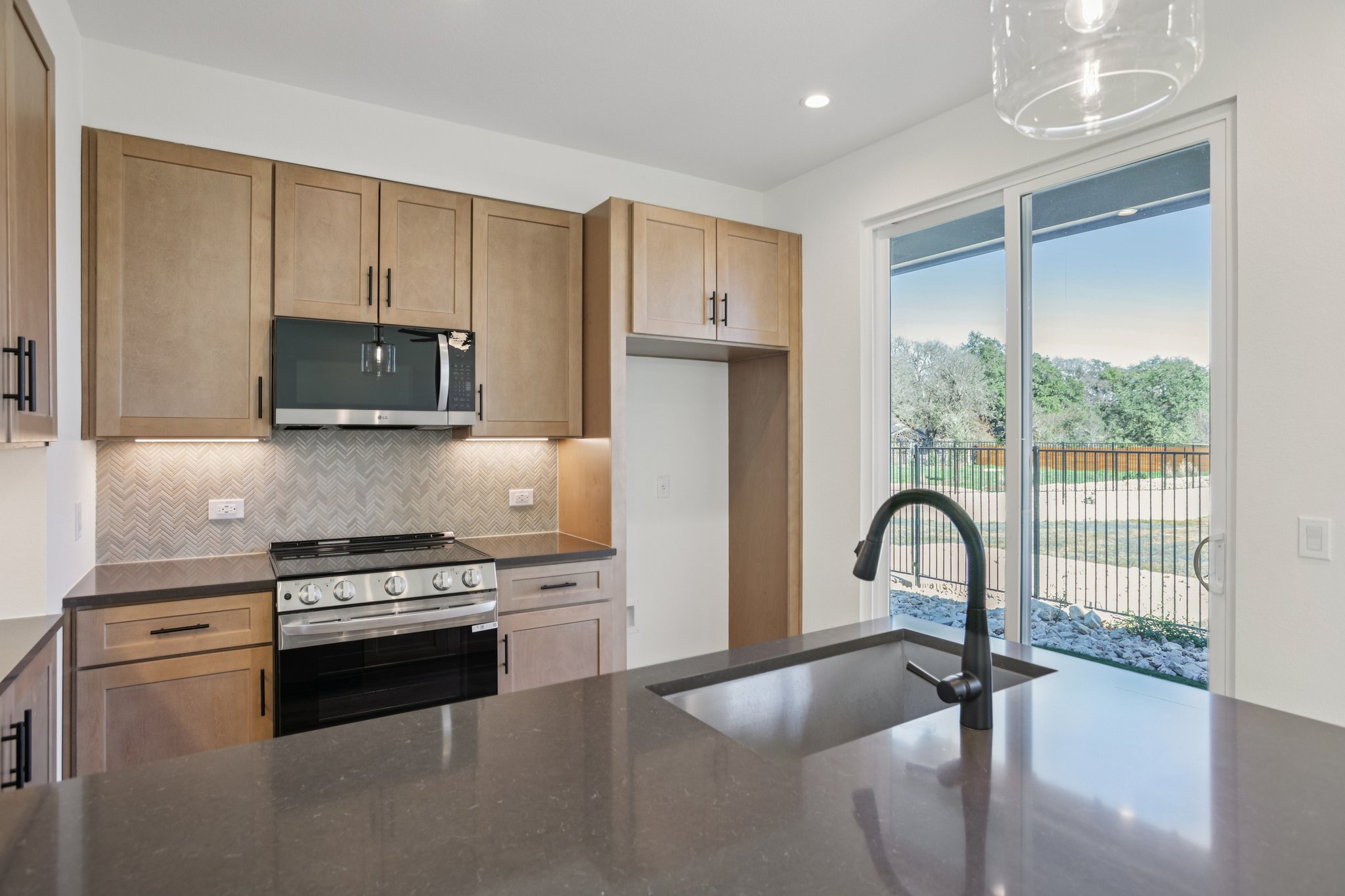 2414 Drew Lane, Unit 5 Austin, TX 78748 - Photo 10 of 24 Kitchen with stainless steel appliances, dark stone counters, decorative backsplash, recessed lighting, and decorative light fixtures