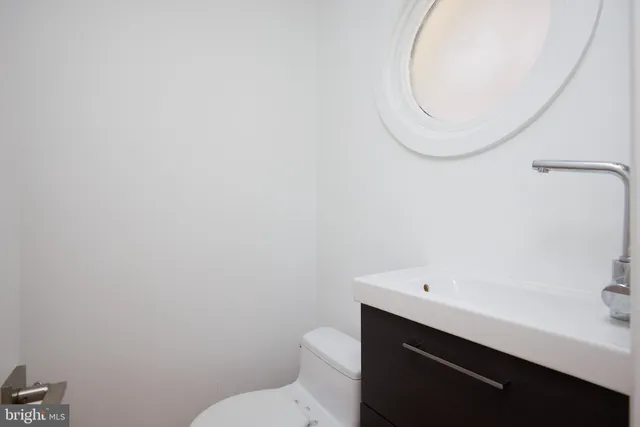 a bathroom with a sink mirror and toilet