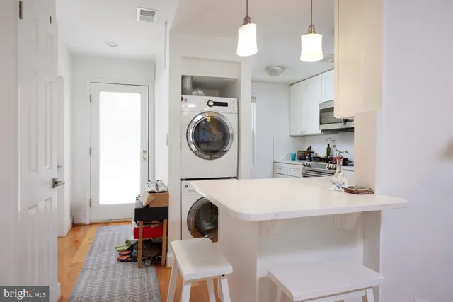 a view of a kitchen area with furniture and wooden floor
