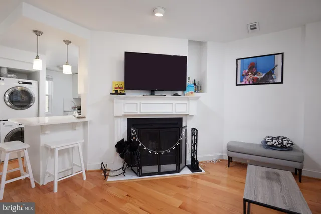 a living room with furniture a flat screen tv and a fireplace