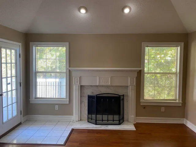 a living room with fireplace and a window