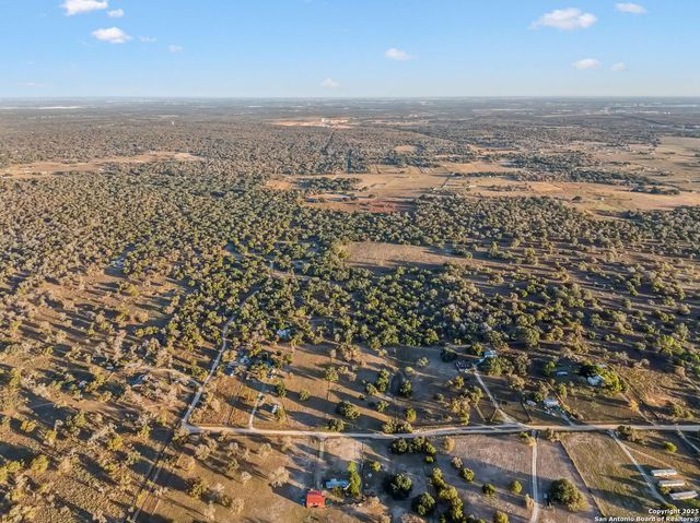 an aerial view of house with yard and mountain view in back