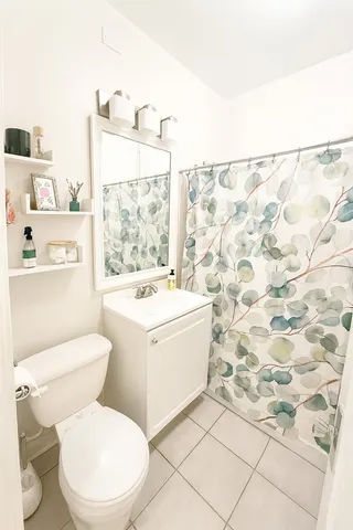 a bathroom with a sink toilet vanity and window
