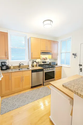 a large kitchen with a stove a sink a microwave and cabinets