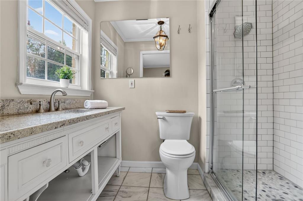 1127 Moores Mill Road Northwest Atlanta, GA 30327 - Photo 12 of 20 a bathroom with a toilet sink and mirror
