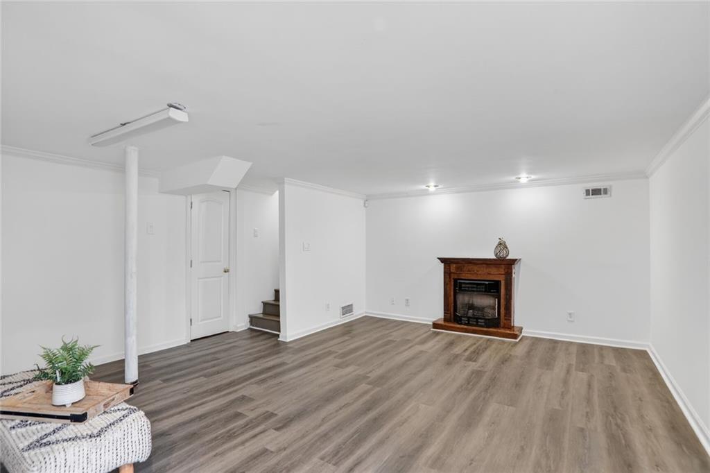 1127 Moores Mill Road Northwest Atlanta, GA 30327 - Photo 18 of 20 a view of empty room with a fireplace and wooden floor