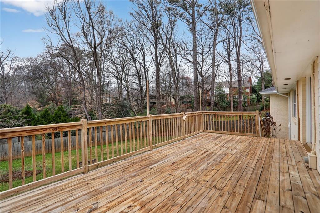 1127 Moores Mill Road Northwest Atlanta, GA 30327 - Photo 2 of 20 a balcony with wooden floor and fence