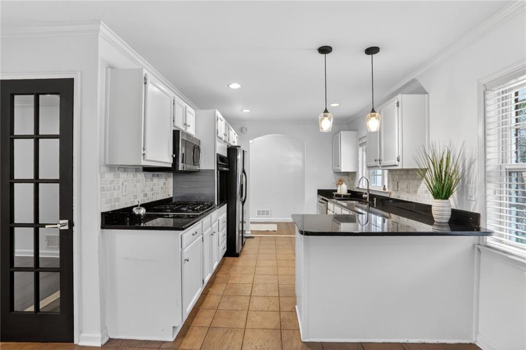 1127 Moores Mill Road Northwest Atlanta, GA 30327 - Photo 4 of 20 a kitchen with stainless steel appliances granite countertop a sink a stove and a wooden floors