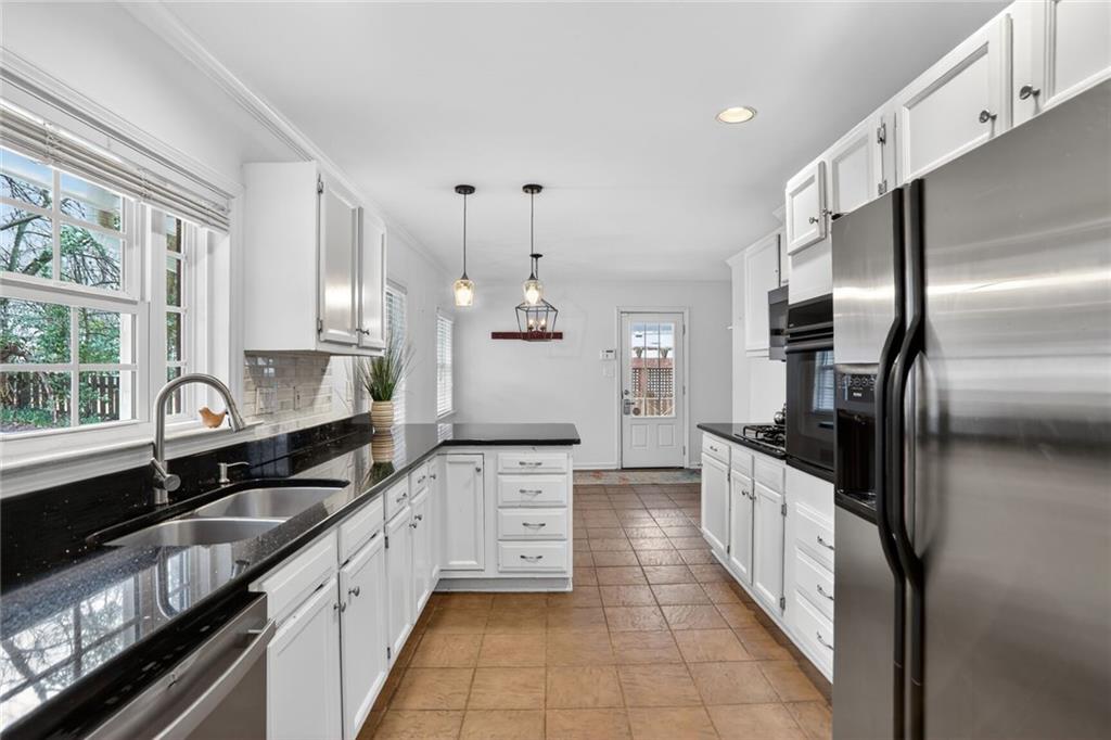 1127 Moores Mill Road Northwest Atlanta, GA 30327 - Photo 5 of 20 a large kitchen with granite countertop a stove sink and refrigerator