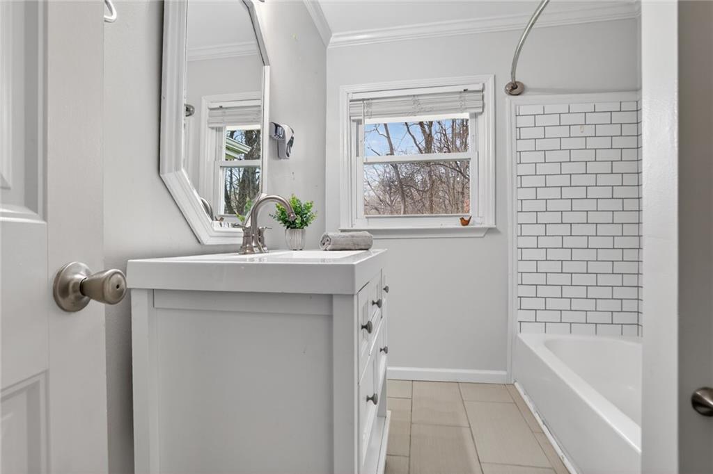 1127 Moores Mill Road Northwest Atlanta, GA 30327 - Photo 6 of 20 a bathroom with a bathtub a sink and a window