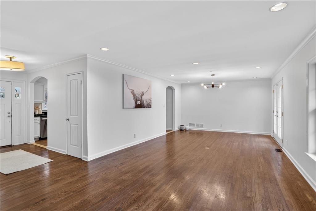1127 Moores Mill Road Northwest Atlanta, GA 30327 - Photo 8 of 20 a view of an empty room with wooden floor and a window